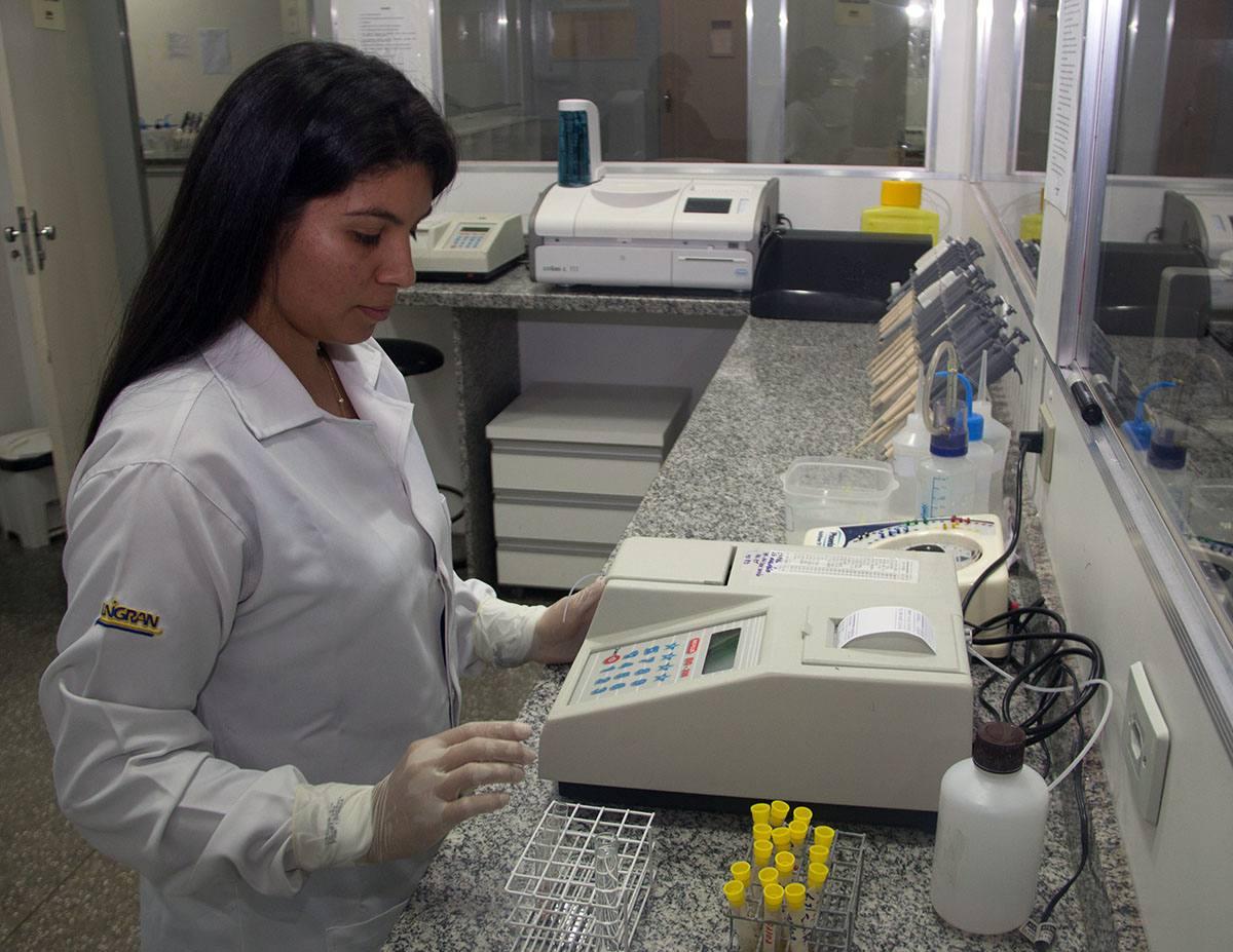 Aluna realizando análise em equipamento sobre bancada de granito